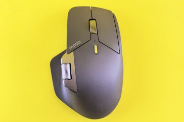 A computer mouse is shown on a yellow surface.
