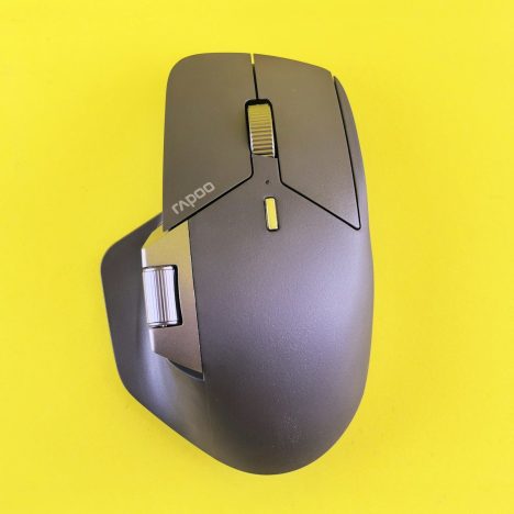A computer mouse is shown on a yellow surface.