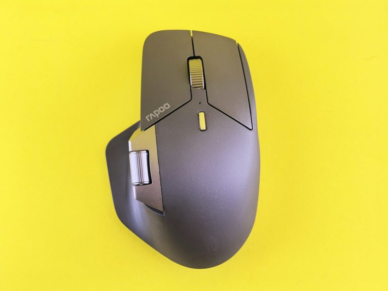 A computer mouse is shown on a yellow surface.