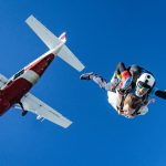 white and red airplane in mid air during daytime. is there a weight limit for skydiving