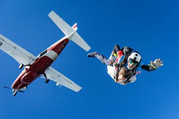 white and red airplane in mid air during daytime. is there a weight limit for skydiving