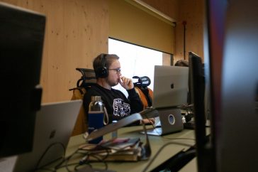 a man sitting at a desk with headphones on