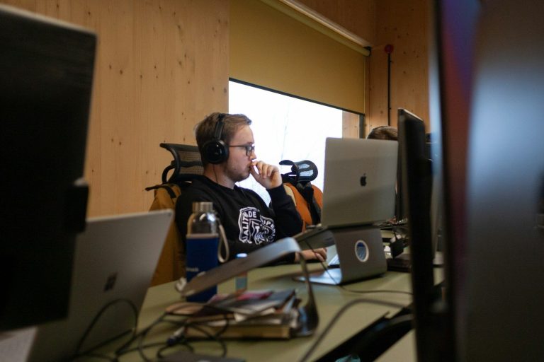 a man sitting at a desk with headphones on