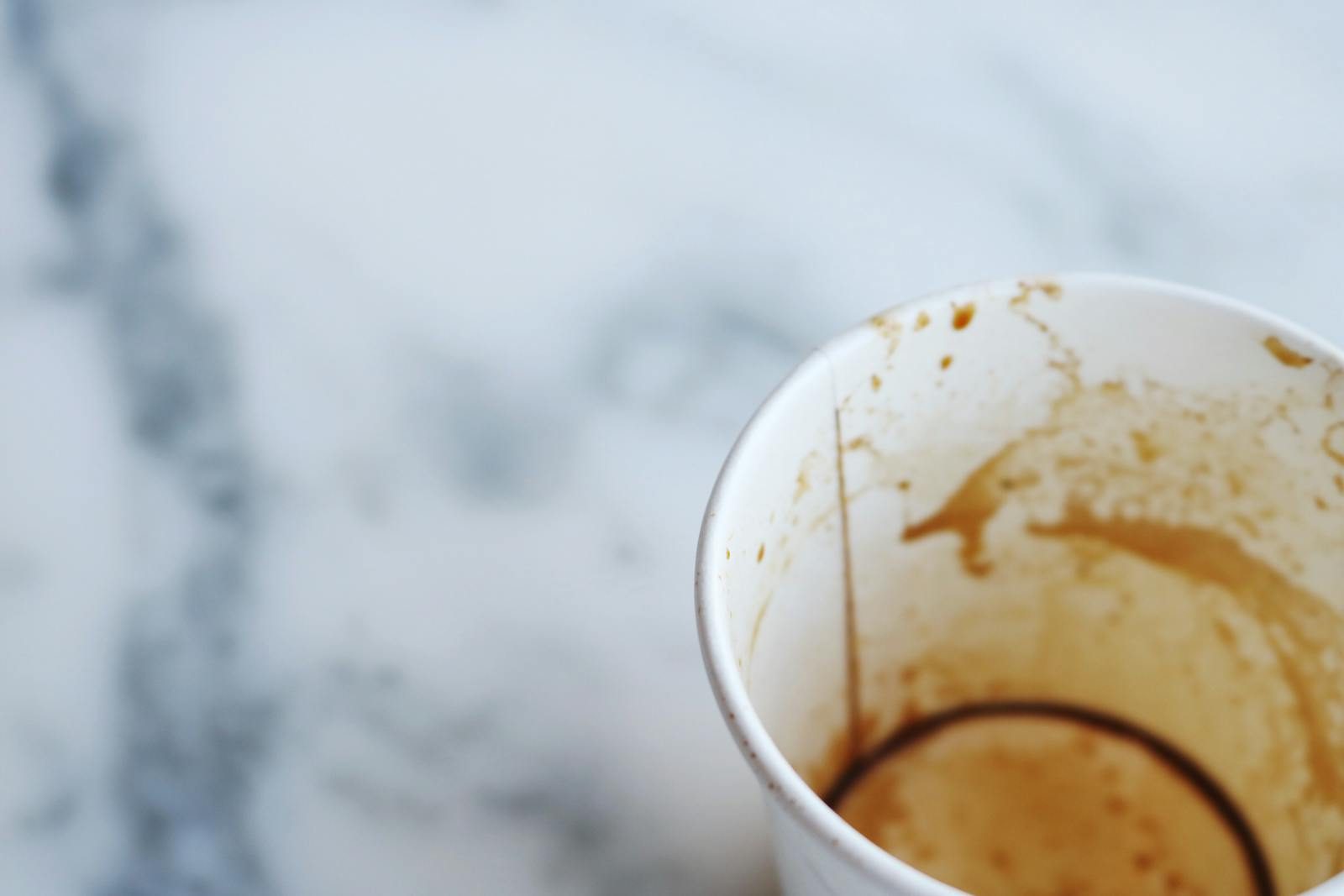 An artistic close-up of an empty coffee cup on a marble surface, capturing a minimalist aesthetic.