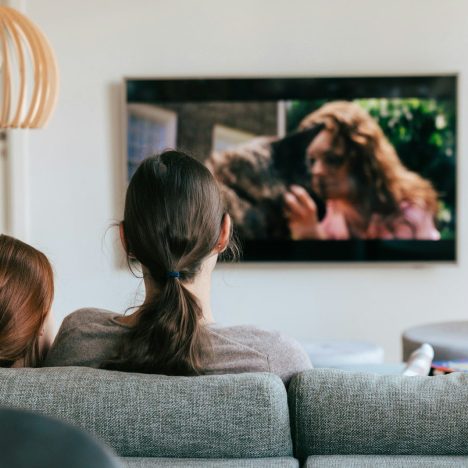 a couple of women sitting on top of a couch