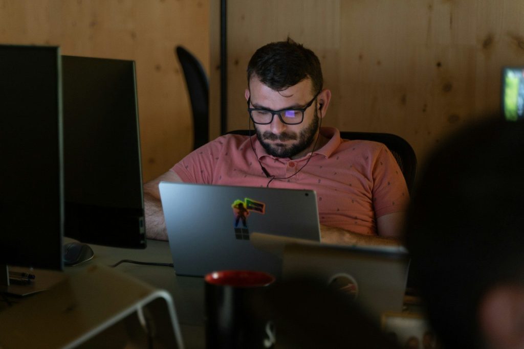 a man sitting in front of a laptop computer