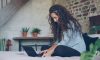 Woman with curly hair typing on a laptop