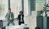 Man and woman dancing in an office.