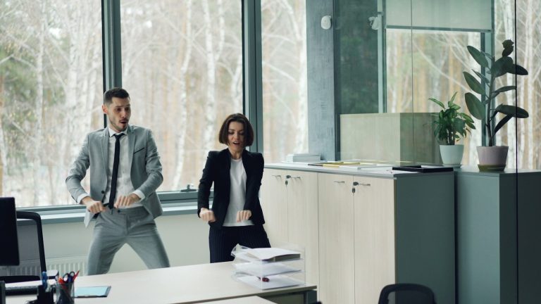 Man and woman dancing in an office.
