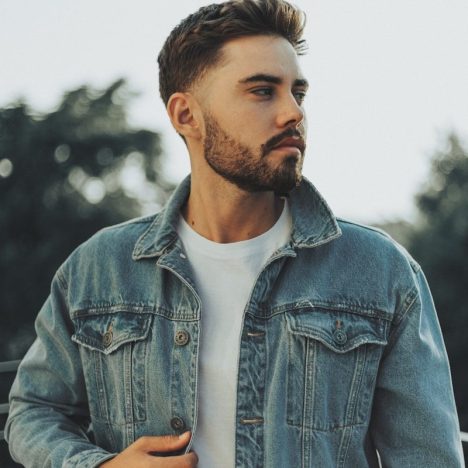 a man with a beard wearing a denim jacket