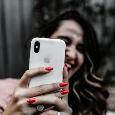 a woman smiles while holding a cell phone