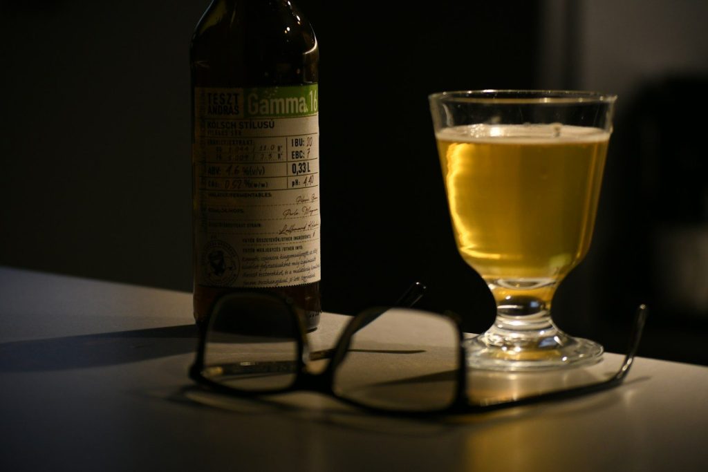 a glass of beer and a bottle on a table