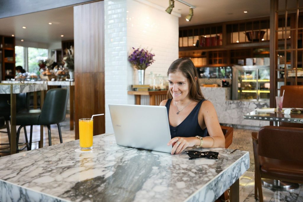 a woman sitting at a table using a laptop computer