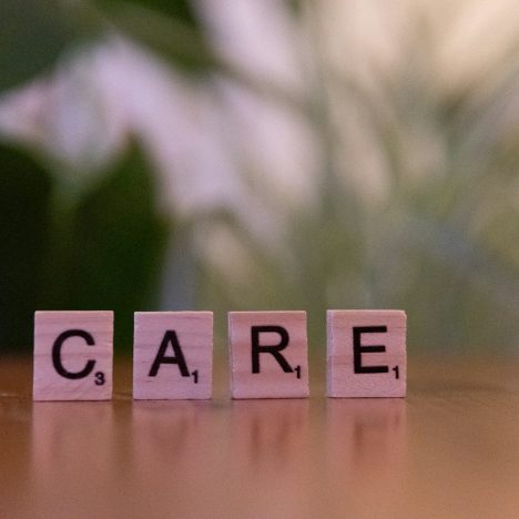 A wooden block spelling care on a table