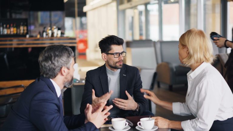 a group of people sitting around a table talking
