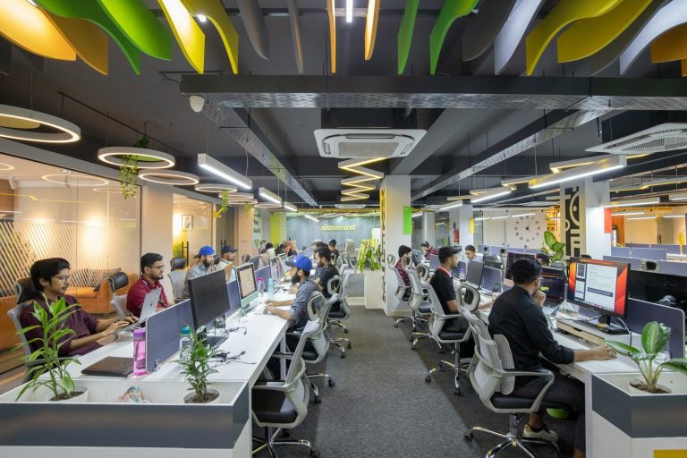 a group of people sitting at desks in an office