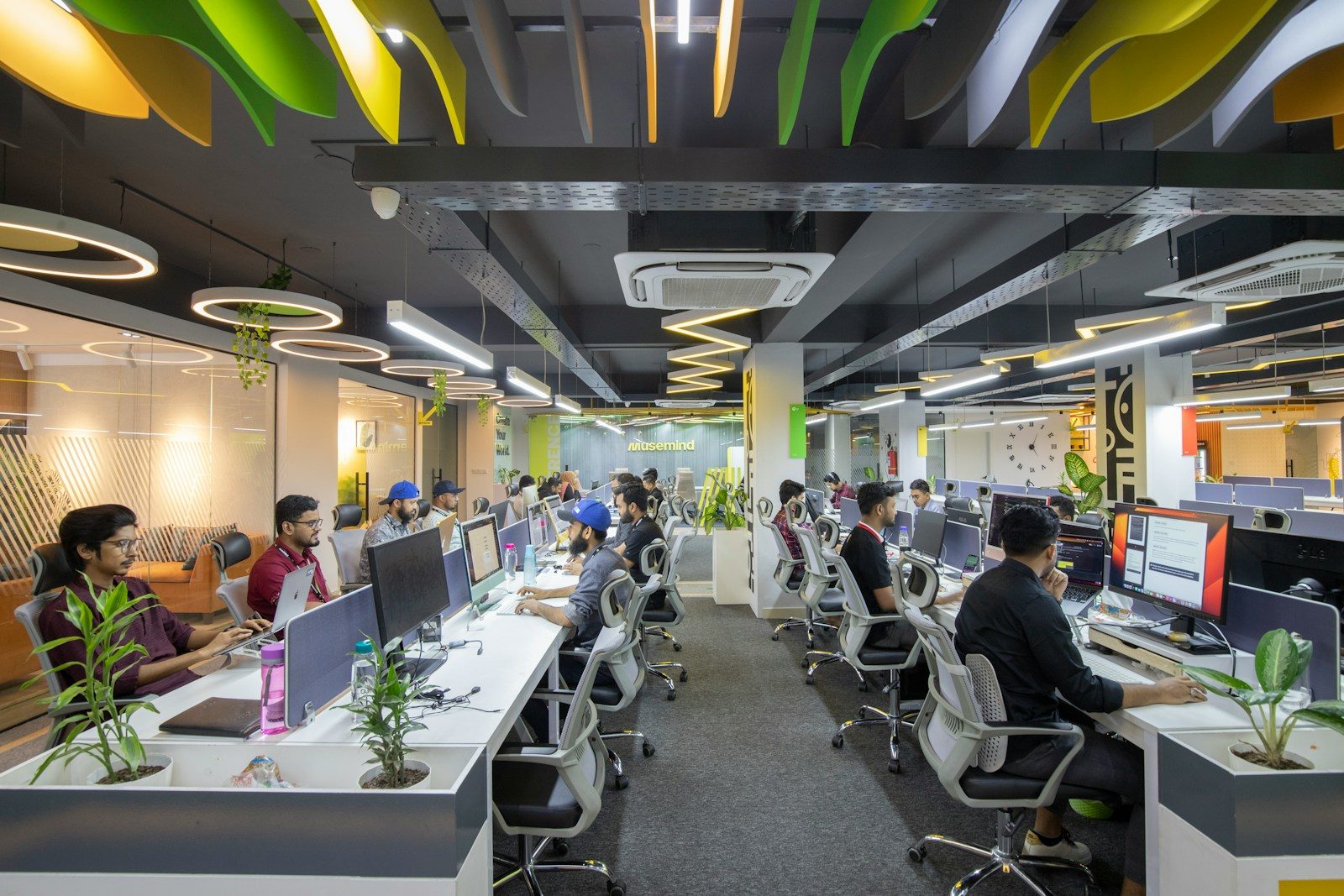 a group of people sitting at desks in an office